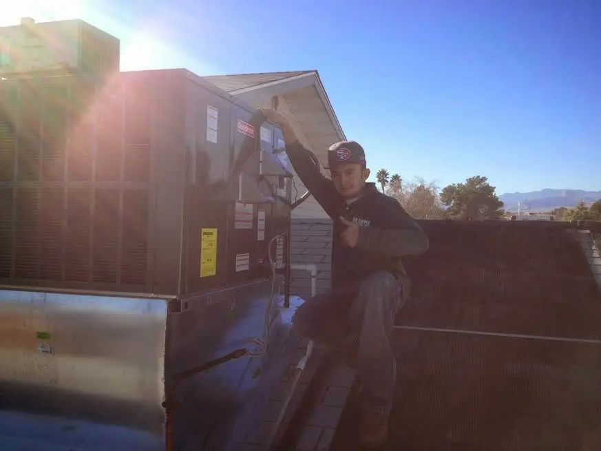 HVAC technician performing AC Tune-Up on a rooftop unit in Nogales